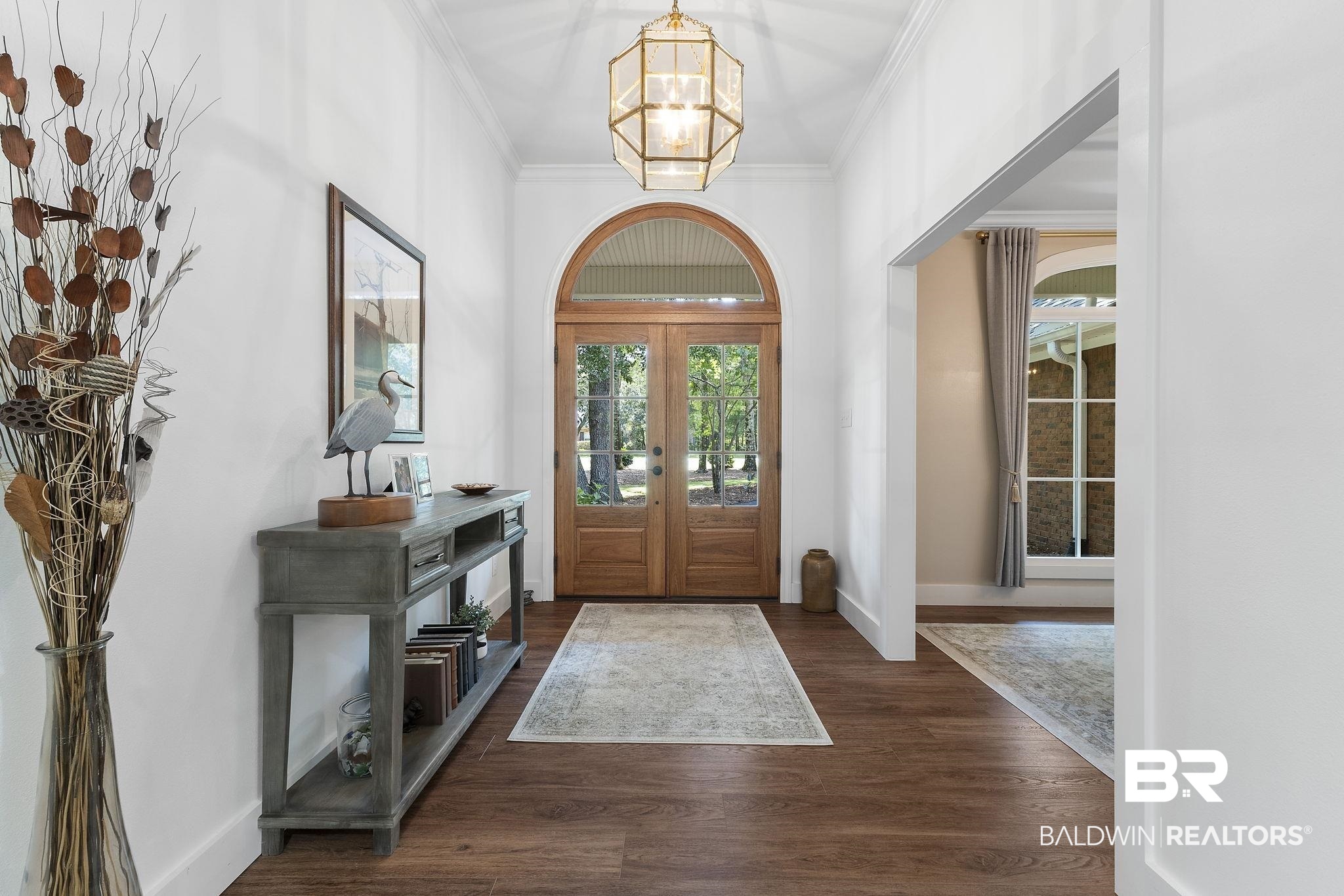 4451 Millhouse Road Gulf Shores, AL 36542 - Photo 5 of 50 Foyer entrance featuring dark hardwood / wood-style floors, french doors, a notable chandelier, and ornamental molding