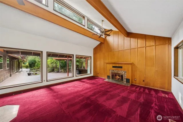 a view of empty room with fireplace and large windows
