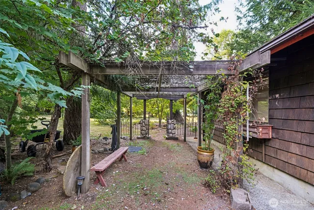 a view of a patio with table and chairs potted plants and large tree