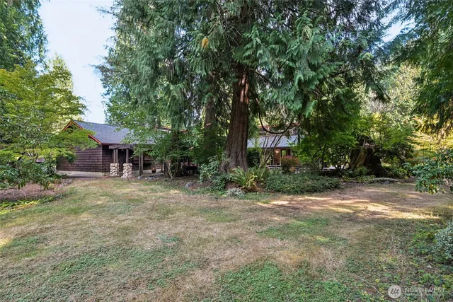an aerial view of a houses with a yard and trees