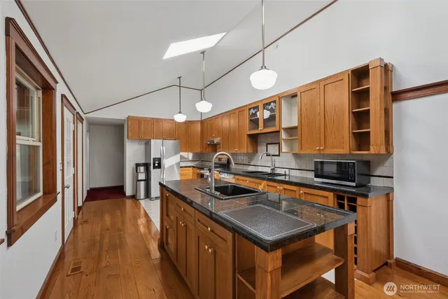 a kitchen that has a sink a stove and a wooden floor