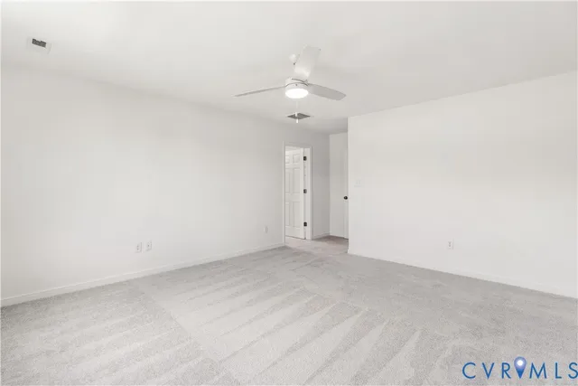an empty room with a window and a ceiling fan