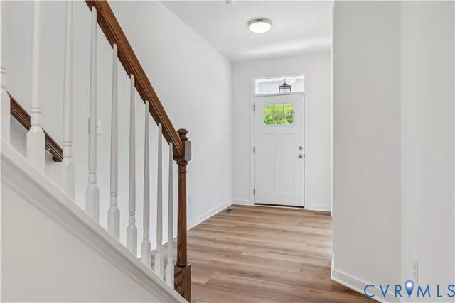 a view of an entryway with wooden floor and stairs