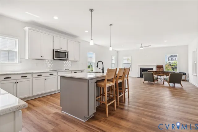 a kitchen with kitchen island granite countertop wooden floors and white cabinets