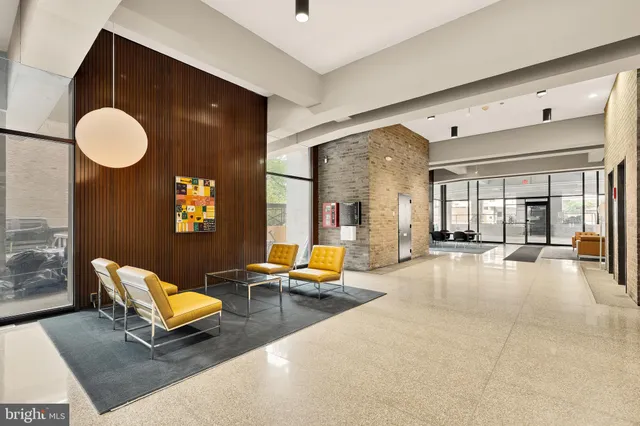 a living room with furniture gym equipment and a large window