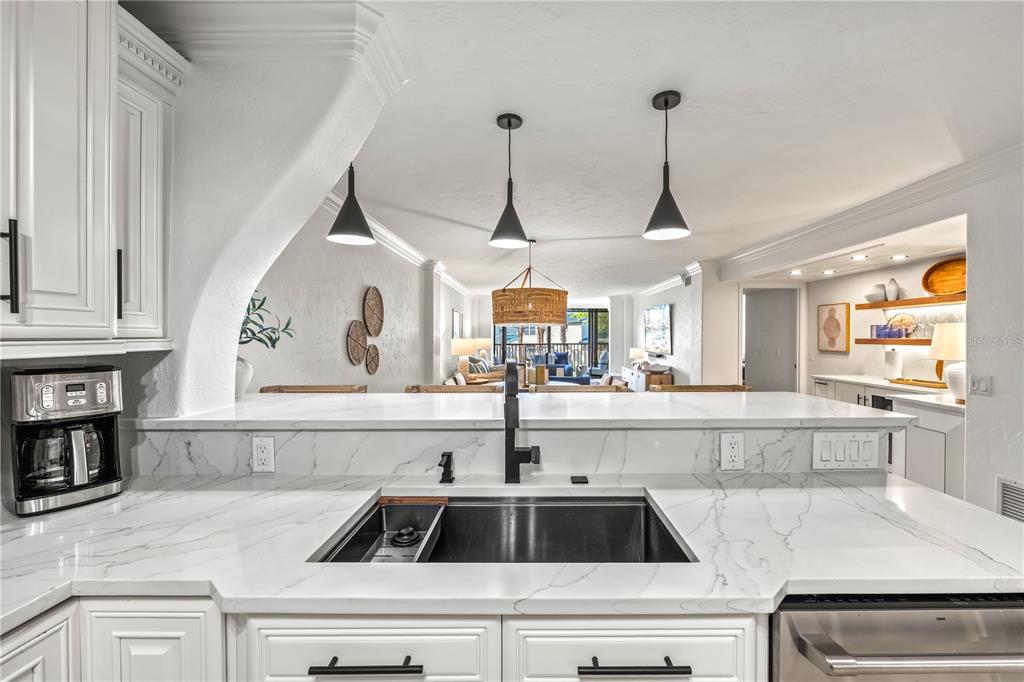 5880 Midnight Pass Road, Unit 210 Sarasota, FL 34242 - Photo 11 of 75 a kitchen with kitchen island a sink a counter space cabinets and appliances