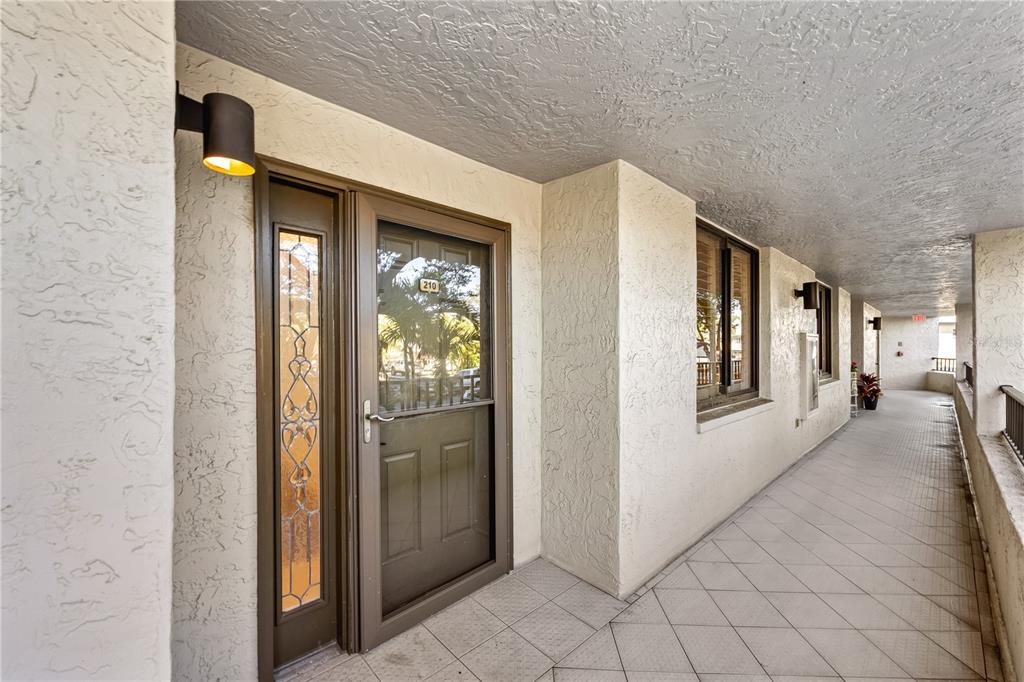 5880 Midnight Pass Road, Unit 210 Sarasota, FL 34242 - Photo 2 of 75 a view of a hallway with toilet and a refrigerator