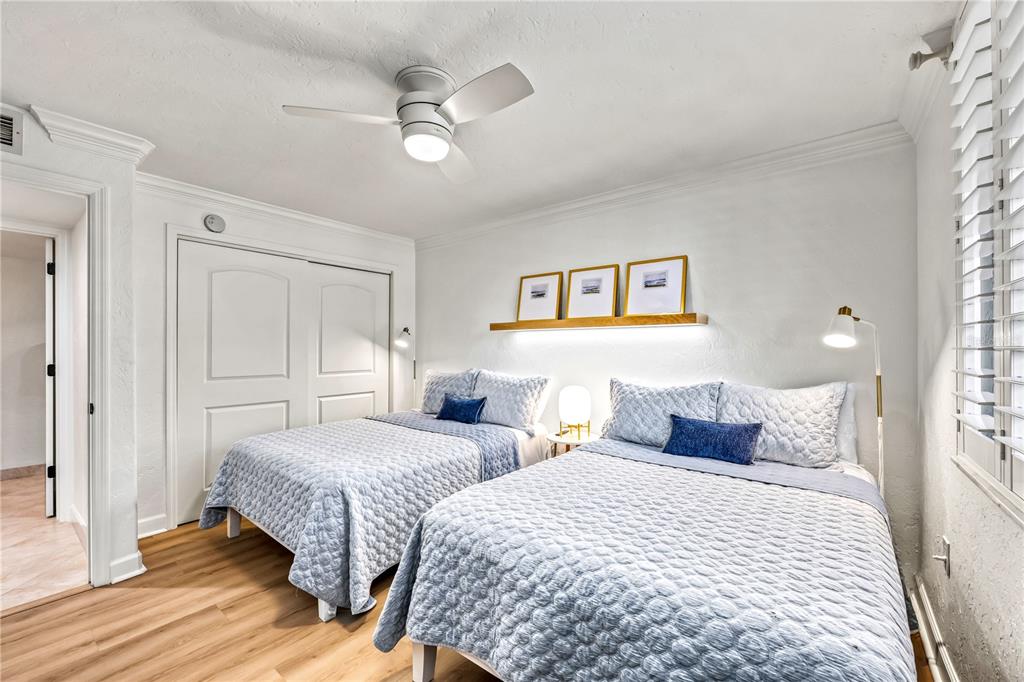 5880 Midnight Pass Road, Unit 210 Sarasota, FL 34242 - Photo 31 of 75 a bedroom with two beds and a chandelier