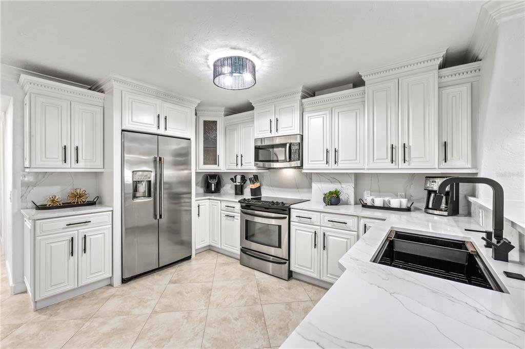 5880 Midnight Pass Road, Unit 210 Sarasota, FL 34242 - Photo 7 of 75 a kitchen with white cabinets and stainless steel appliances
