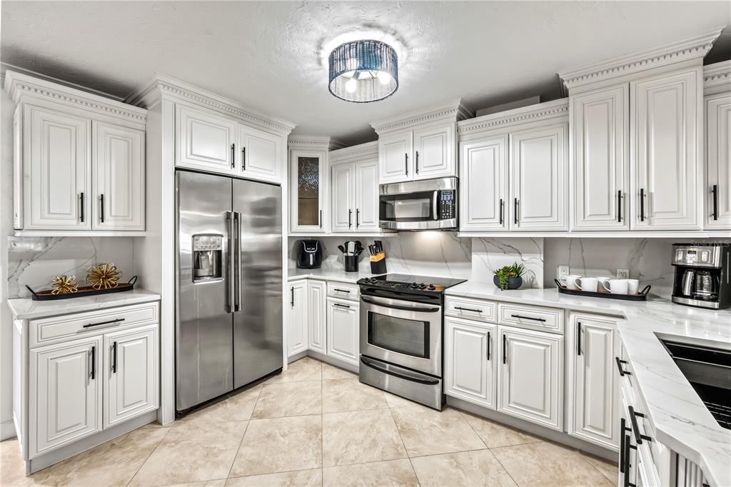 5880 Midnight Pass Road, Unit 210 Sarasota, FL 34242 - Photo 9 of 75 a kitchen with white cabinets stainless steel appliances and a window