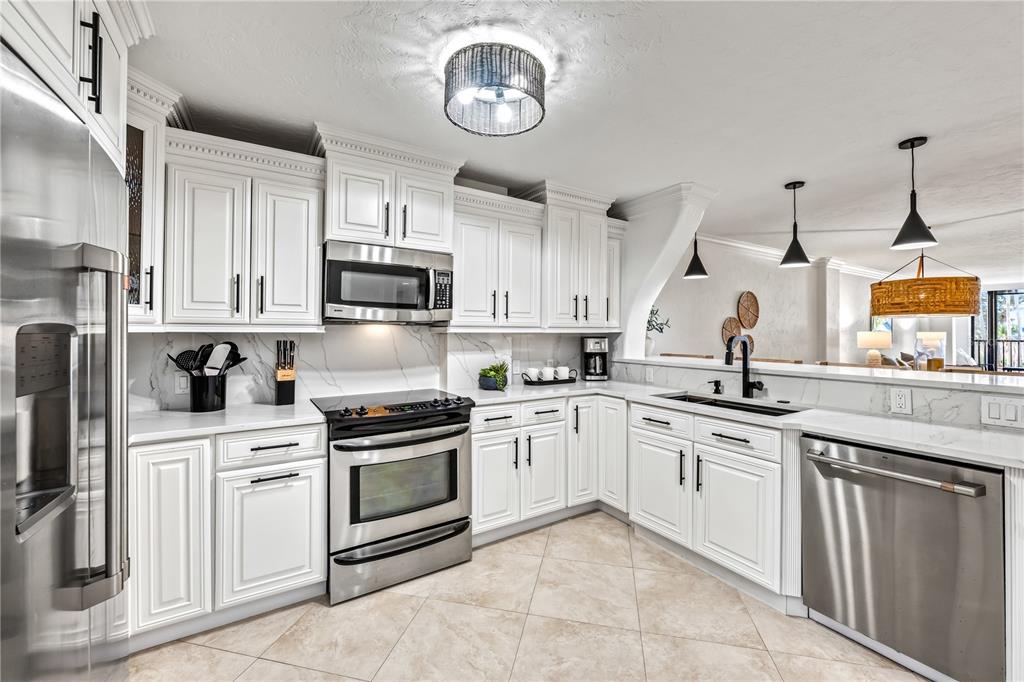 5880 Midnight Pass Road, Unit 210 Sarasota, FL 34242 - Photo 10 of 75 a kitchen with cabinets stainless steel appliances and a window