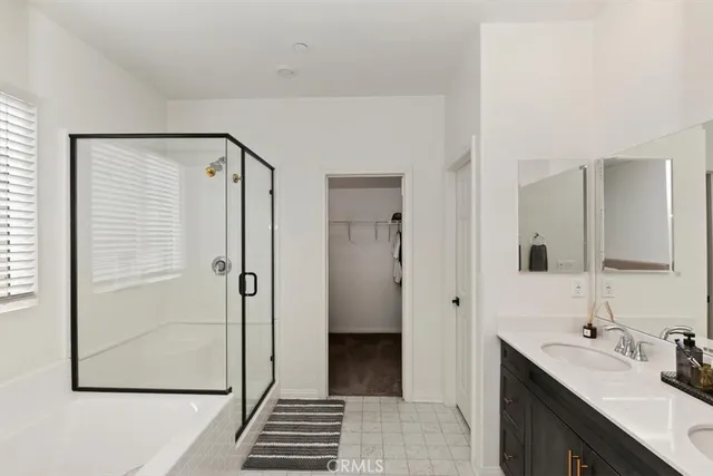 a bathroom with a double vanity sink a mirror and a shower