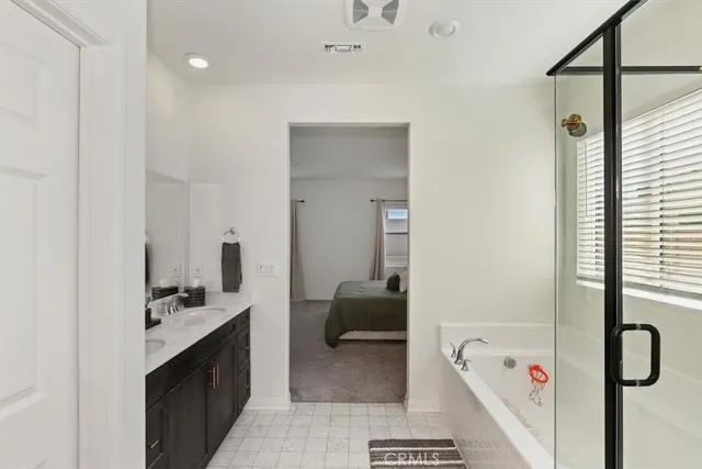 a en suite bathroom with a double vanity sink a mirror and a shower