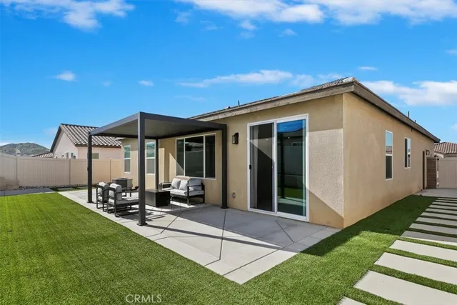 a view of a house with backyard sitting area and garden