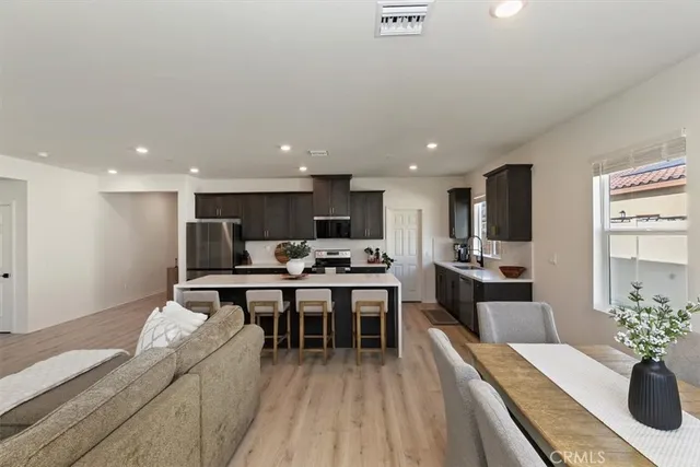 a living room with stainless steel appliances furniture stove and kitchen view