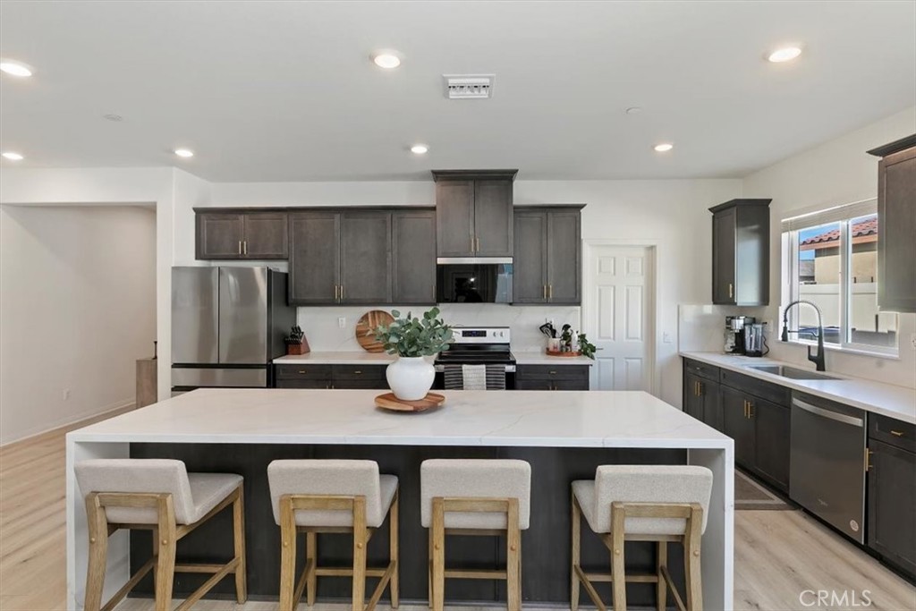 29224 Outback Lane Winchester, CA 92596 - Photo 10 of 35 a kitchen with a dining table chairs and refrigerator