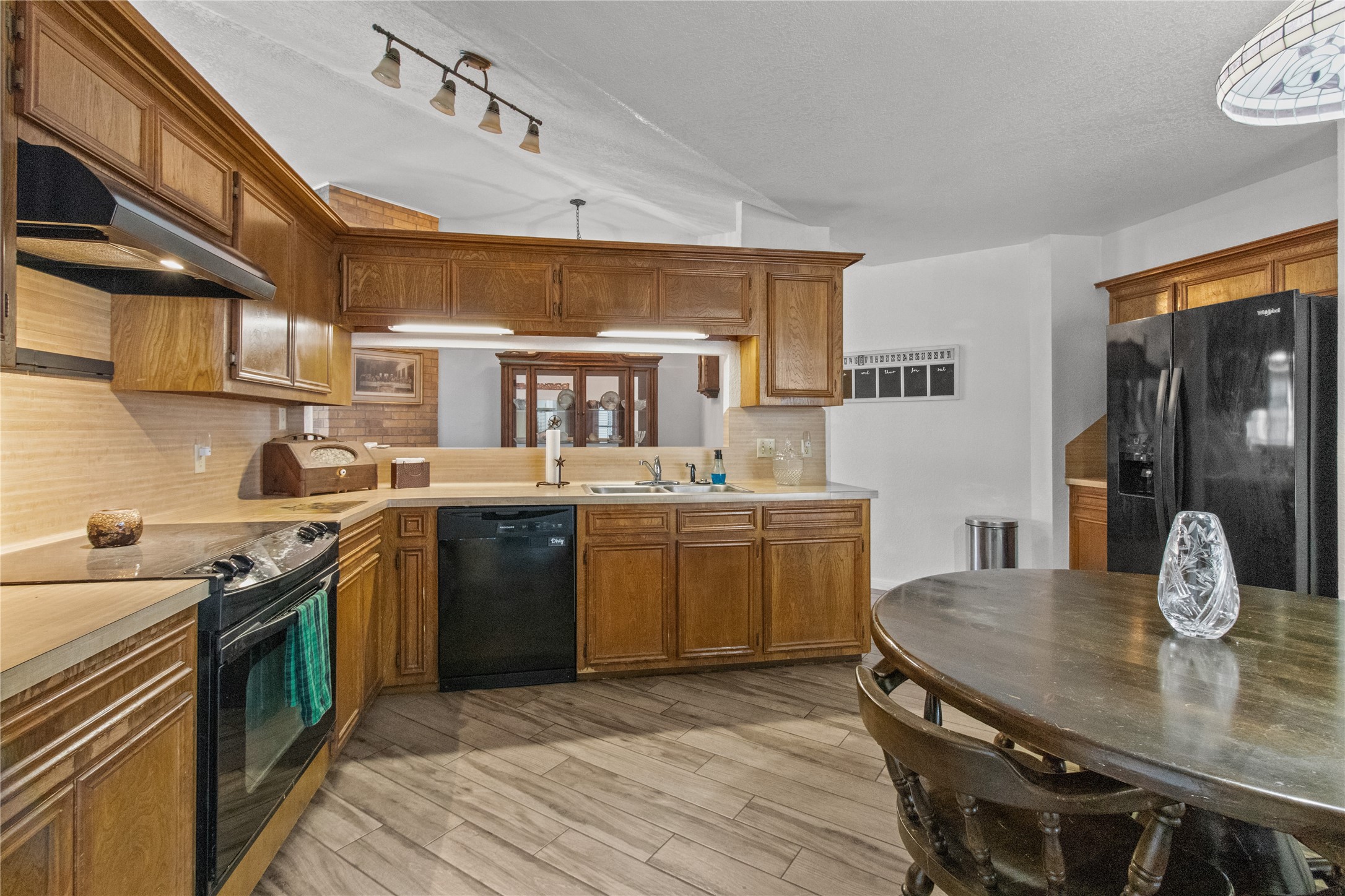 9 Colony Square Angleton, TX 77515 - Photo 6 of 23 a kitchen with a sink dishwasher a stove a microwave oven with a dining table and chairs
