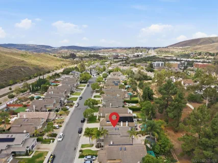 an aerial view of residential houses with outdoor space and trees