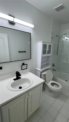 a bathroom with a double vanity sink toilet mirror and bathtub