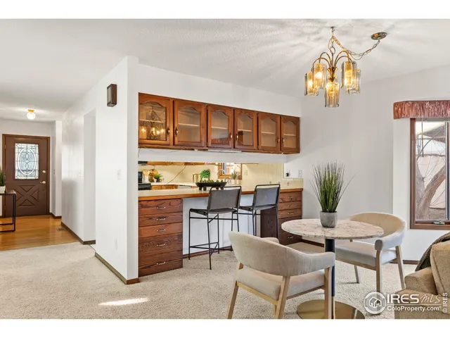 a living room with stainless steel appliances kitchen island granite countertop a dining table and chairs with wooden floor