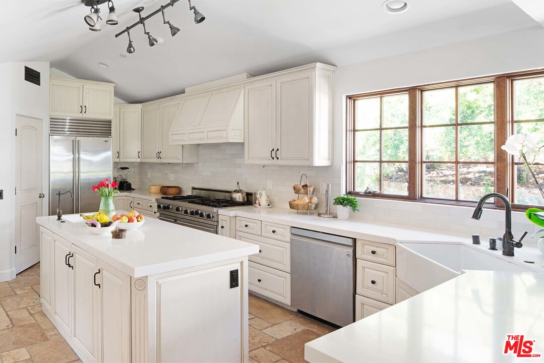 2251 Cold Canyon Road Calabasas, CA 91302 - Photo 11 of 47 a kitchen that has a lot of white cabinets and wooden floor