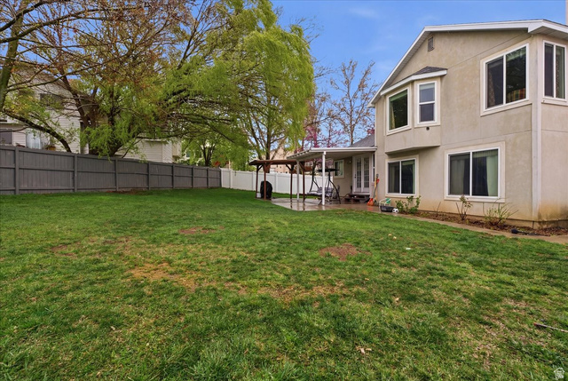 7975 Showcase Lane Sandy, UT 84094 - Photo 26 of 29 Fenced backyard featuring a patio area and large open grass area