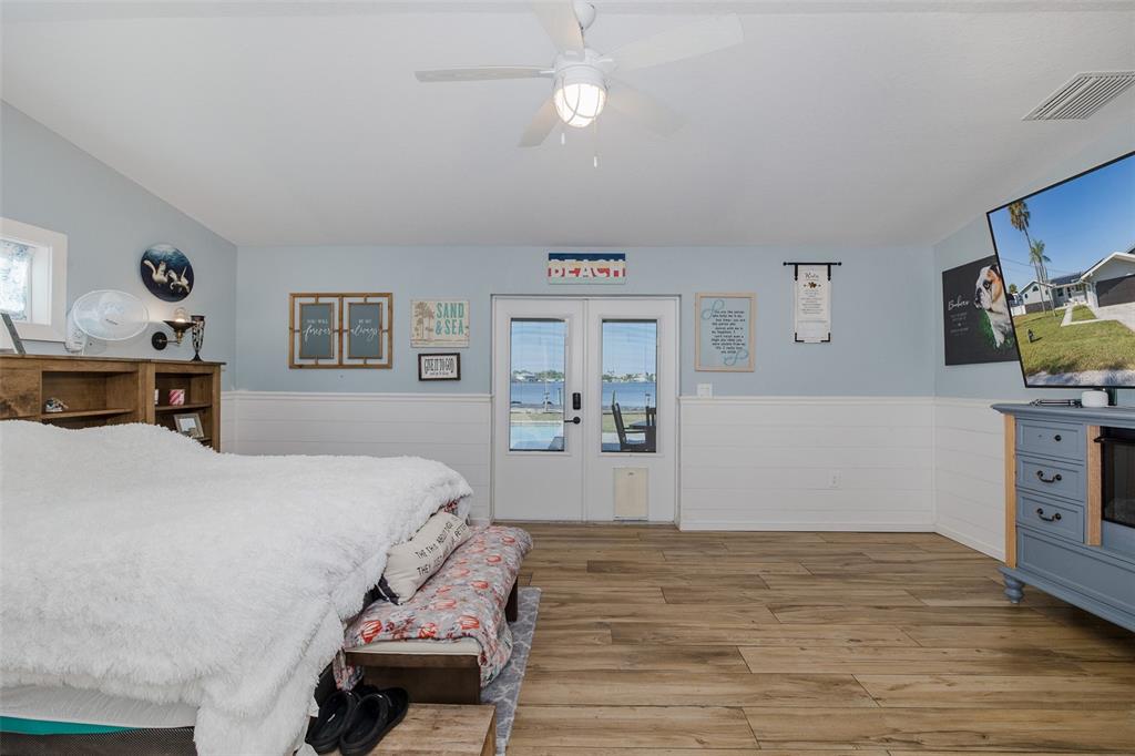 8211 Hayward Lane Port Richey, FL 34668 - Photo 16 of 65 a bedroom with a bed and wooden floor