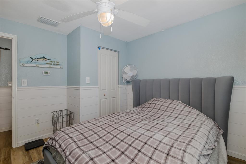 8211 Hayward Lane Port Richey, FL 34668 - Photo 24 of 65 a bedroom with a bed and painting on the wall