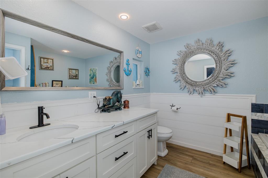 8211 Hayward Lane Port Richey, FL 34668 - Photo 34 of 65 a bathroom with a toilet a sink and mirror