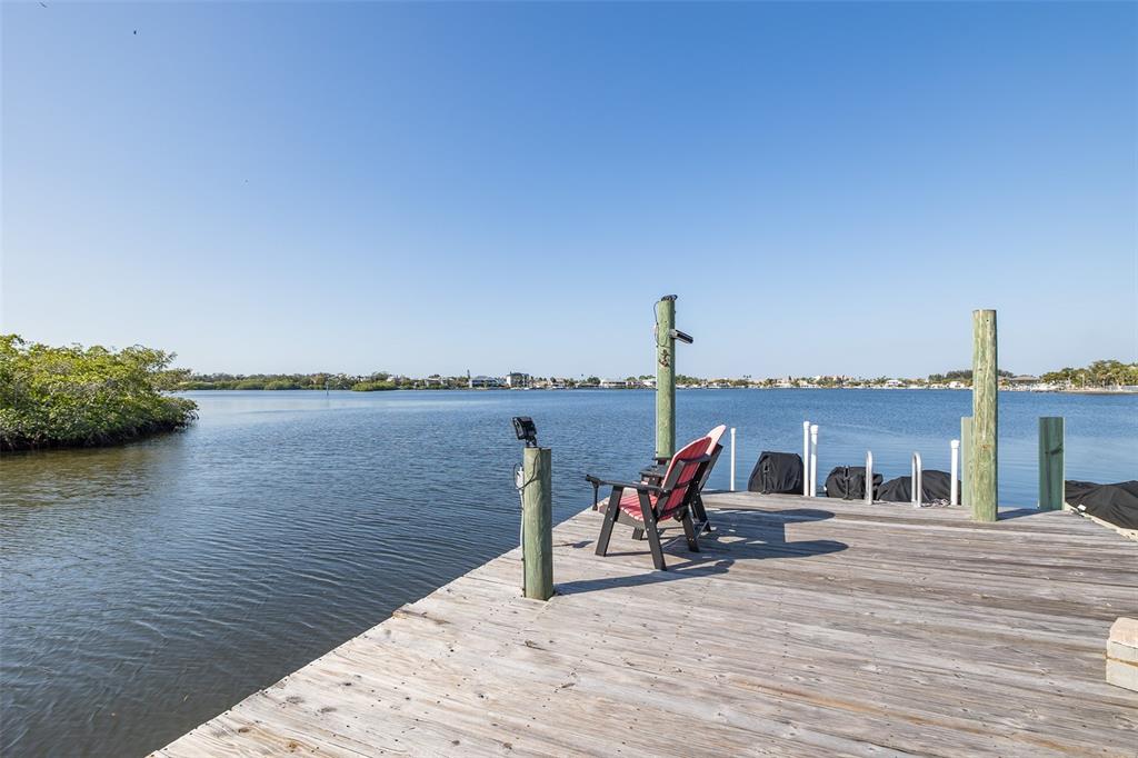 8211 Hayward Lane Port Richey, FL 34668 - Photo 49 of 65 a roof deck with table and chairs a barbeque with wooden floor