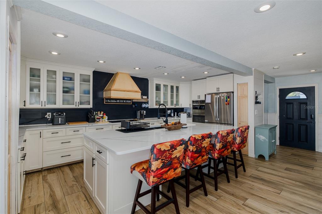 8211 Hayward Lane Port Richey, FL 34668 - Photo 6 of 65 a kitchen with stainless steel appliances white cabinets and wooden floor