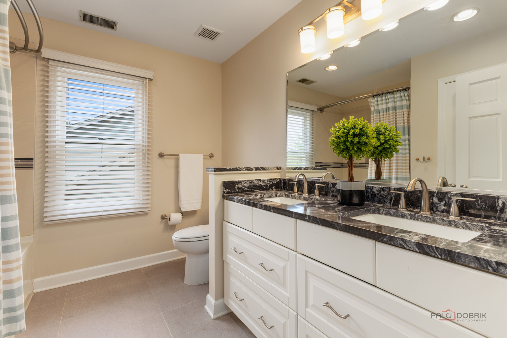 2965 Keystone Road Northbrook, IL 60062 - Photo 26 of 40 a bathroom with a double vanity sink a toilet and a mirror