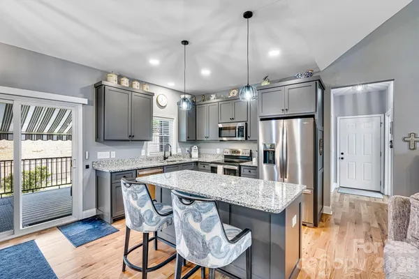 a kitchen with stainless steel appliances granite countertop a kitchen island a stove a table and chairs