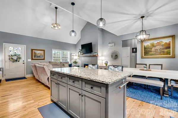 a view of kitchen island a sink wooden floor and living room view