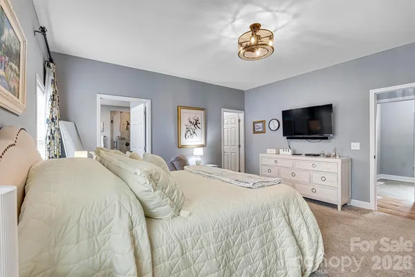 a spacious bedroom with a bed and a flat screen tv