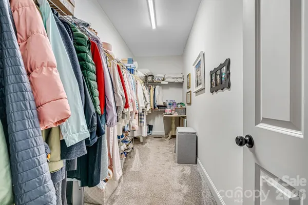 a view of walk in closet with clothes and shoes