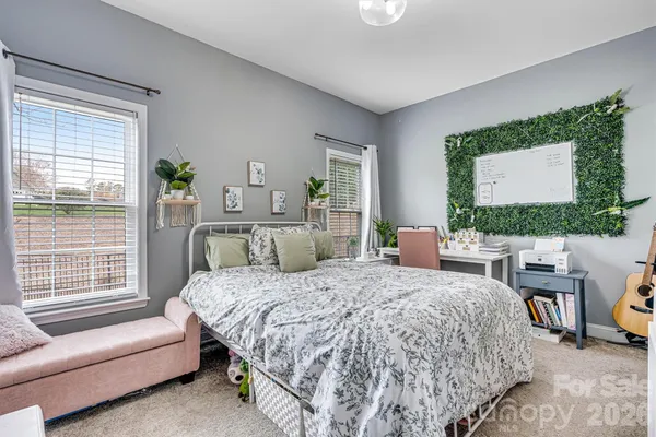 a bedroom with a bed a couch and a window