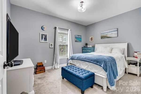 a spacious bedroom with a bed and a flat screen tv