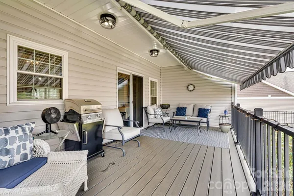 a view of a deck with table and chairs with wooden floor and fence