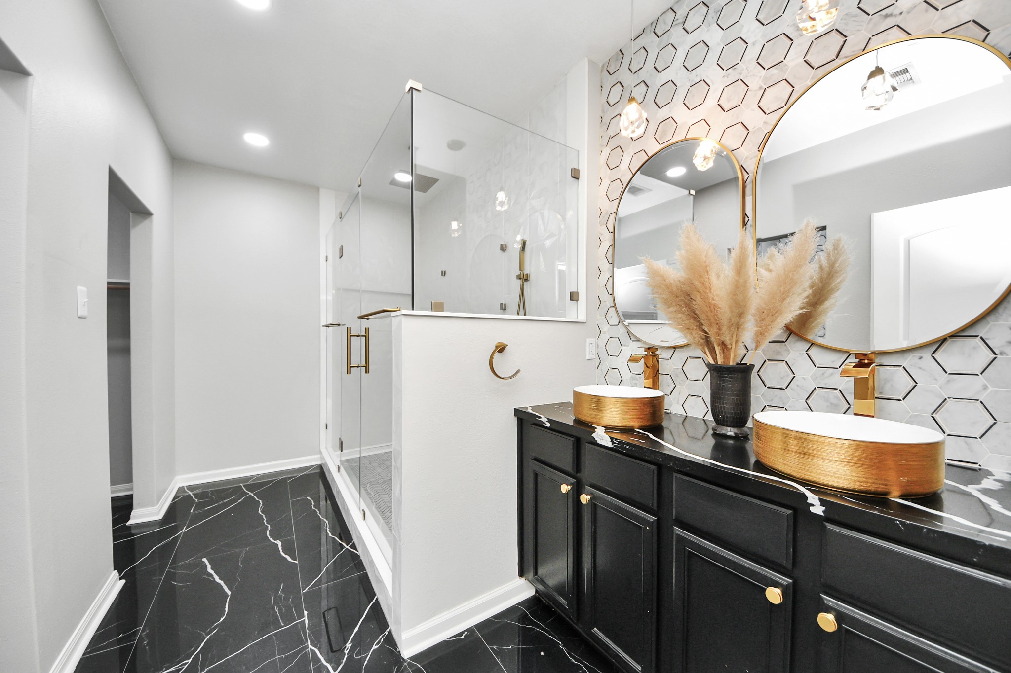 6931 Primrose Road Baytown, TX 77521 - Photo 21 of 50 Luxurious primary bath with dual gold-accented vanities, walk-in glass shower, and modern tile finishes.