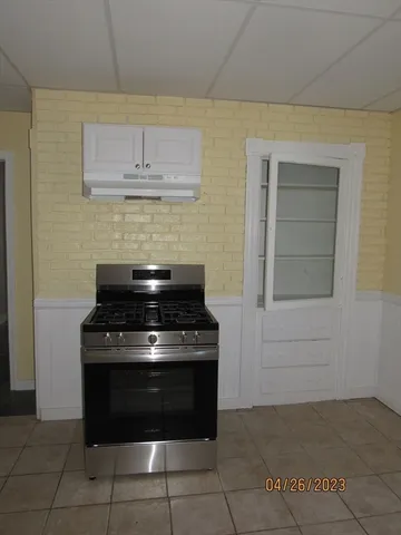 a stove top oven sitting inside of a kitchen