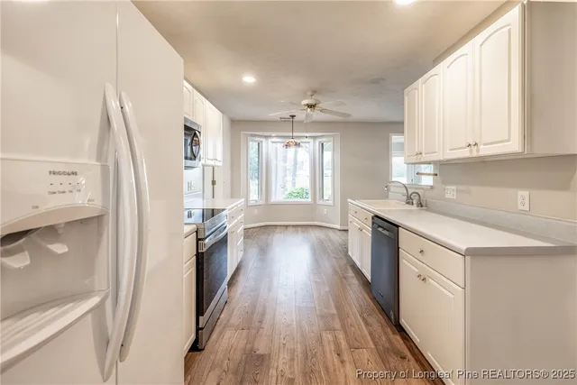 a kitchen with a refrigerator a sink and wooden floor