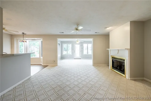 an empty room with windows and fireplace