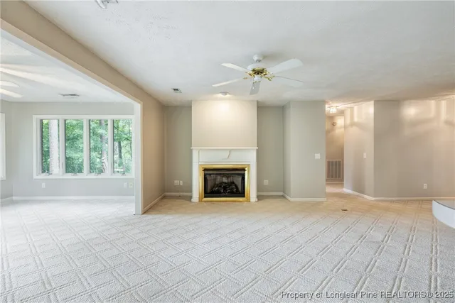 a view of an empty room with a fireplace and a window