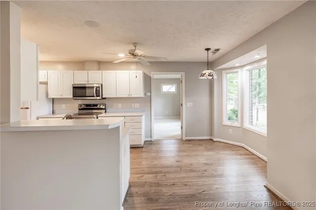 a kitchen with kitchen island granite countertop a sink cabinets and stainless steel appliances