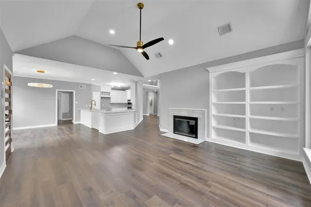 a view of an empty room with a fireplace and a window