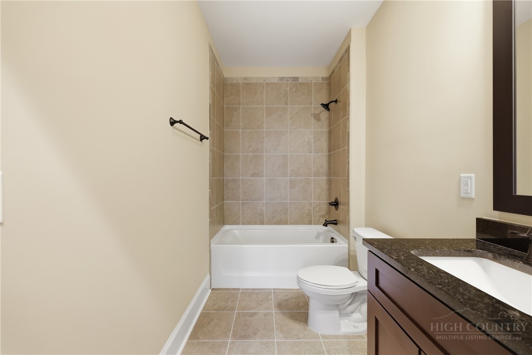 155 Gateway Drive, Unit 101 Boone, NC 28607 - Photo 18 of 50 a bathroom with a granite countertop bathtub shower sink vanity and toilet