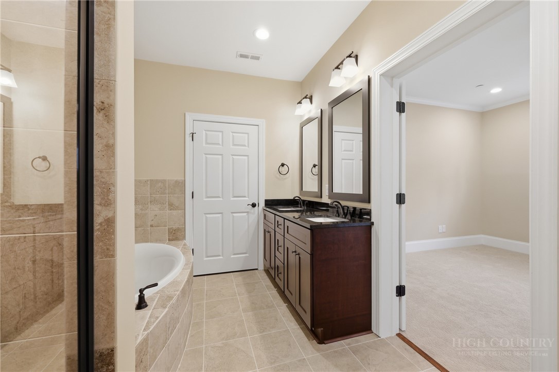 155 Gateway Drive, Unit 101 Boone, NC 28607 - Photo 25 of 50 a spacious bathroom with a granite countertop sink a toilet and shower
