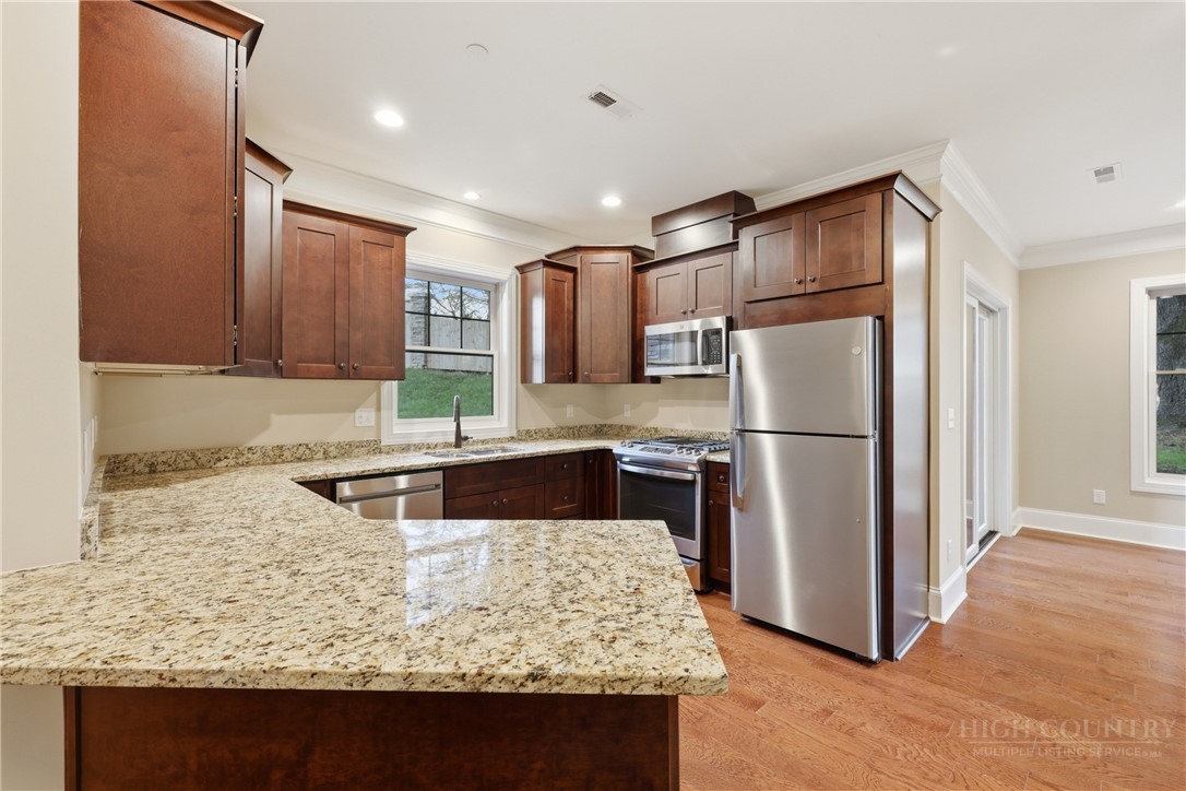 155 Gateway Drive, Unit 101 Boone, NC 28607 - Photo 4 of 50 a kitchen with kitchen island granite countertop a sink refrigerator and microwave