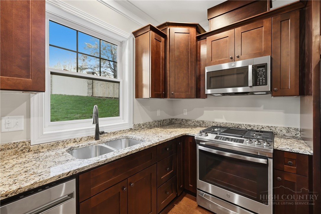155 Gateway Drive, Unit 101 Boone, NC 28607 - Photo 5 of 50 a kitchen with granite countertop a sink stainless steel appliances and cabinets